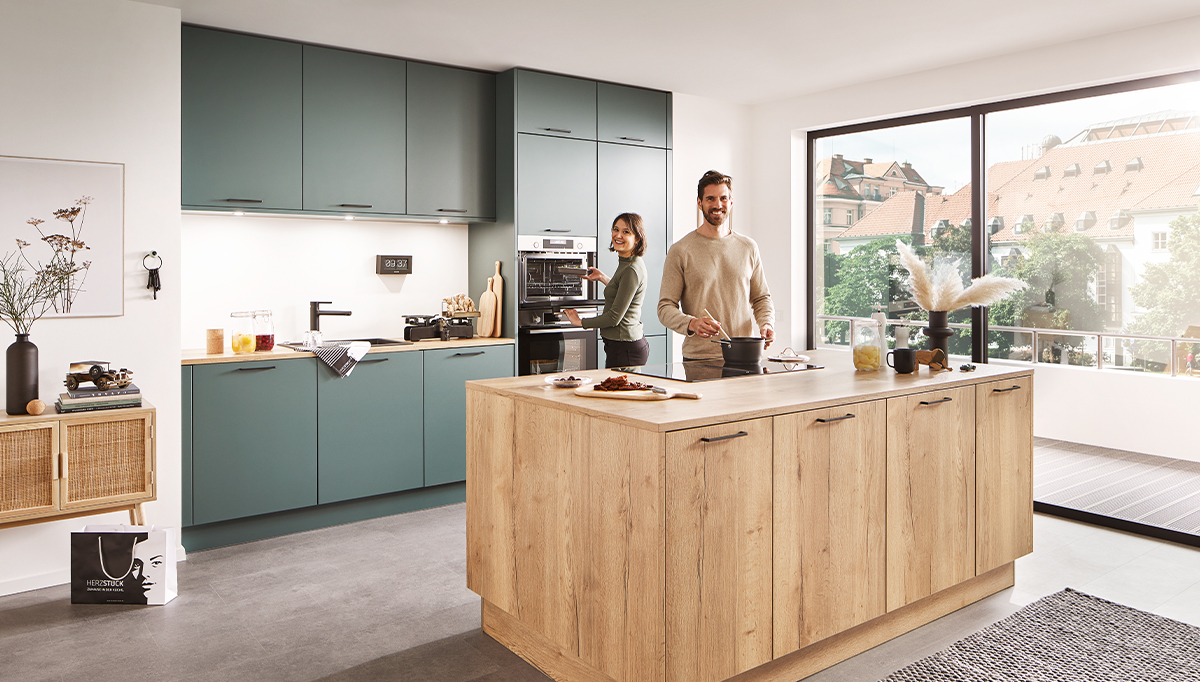 happy young couple standing in new modern kitchen